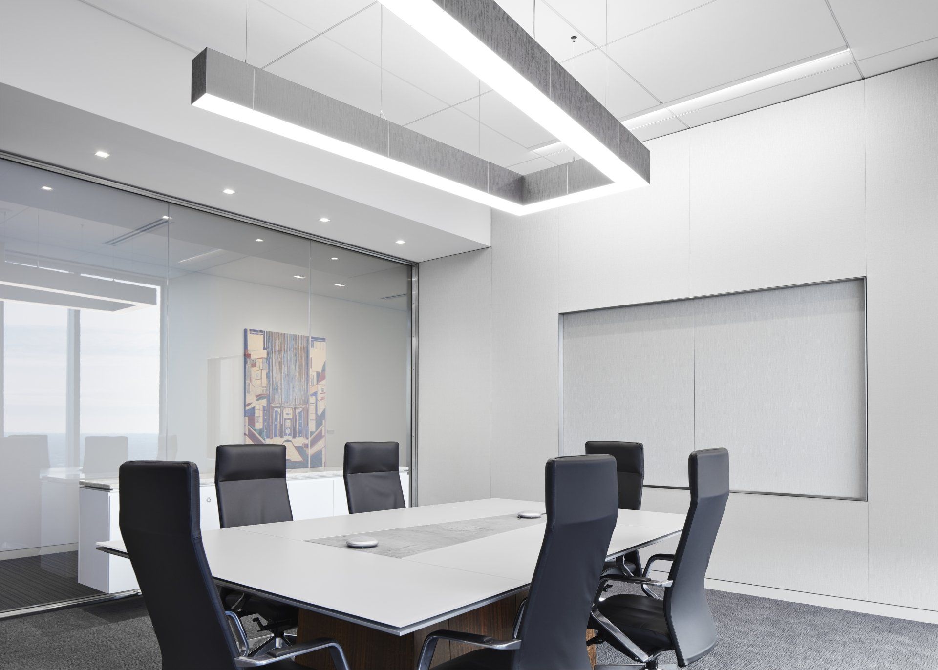 A conference room with a long table and chairs.