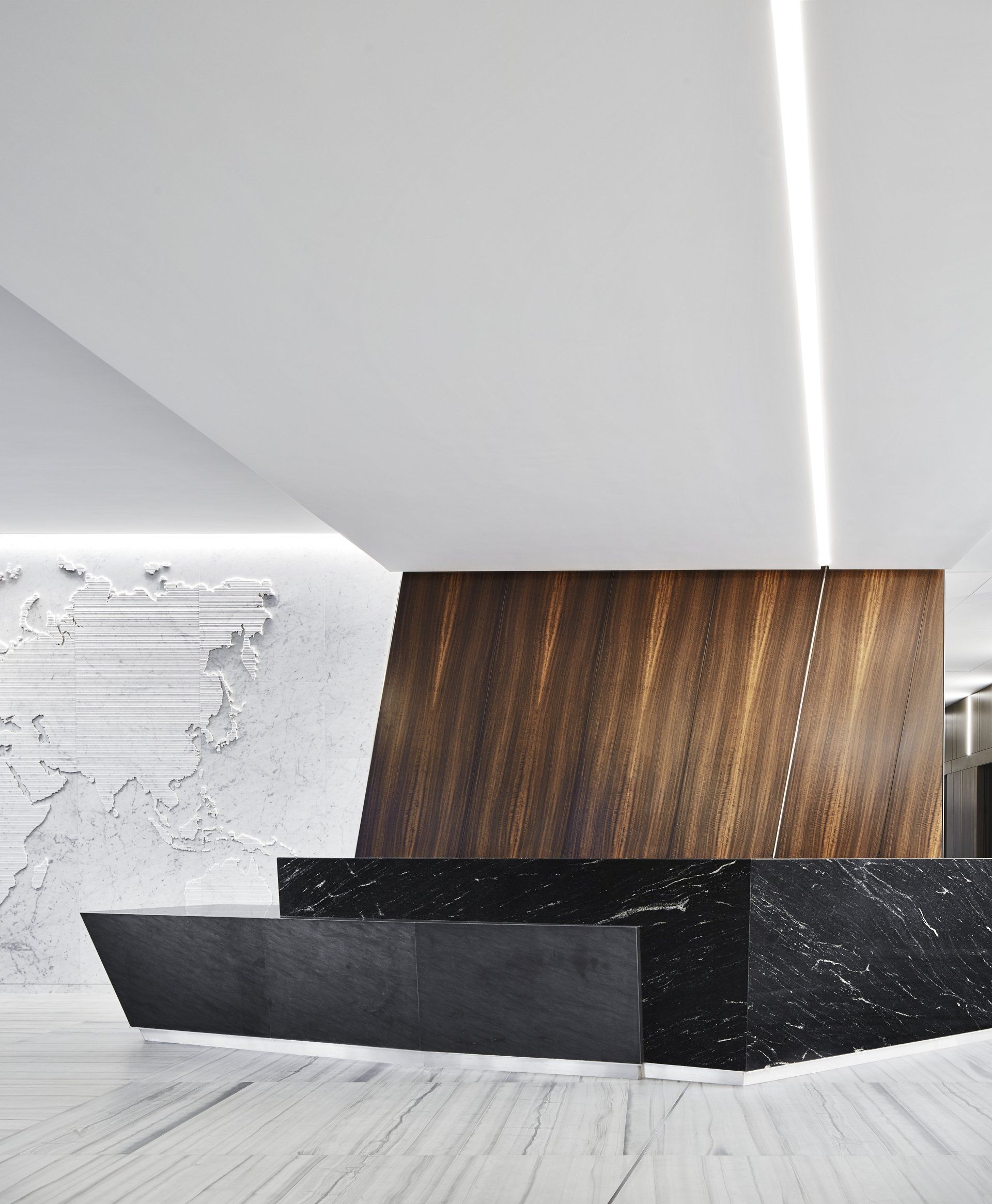 A reception area with a black counter and a wooden wall