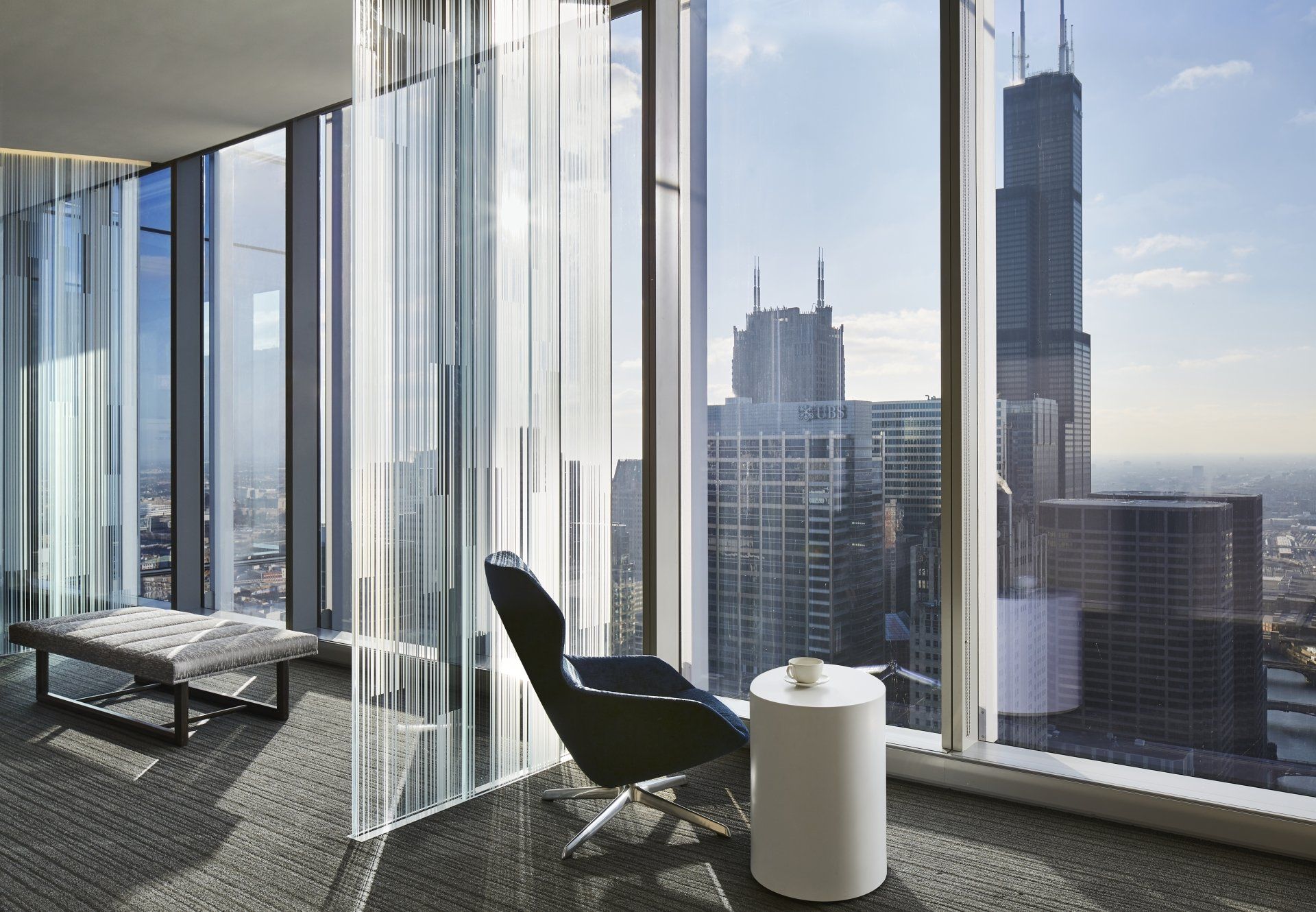 A chair and a table in a room with a view of a city