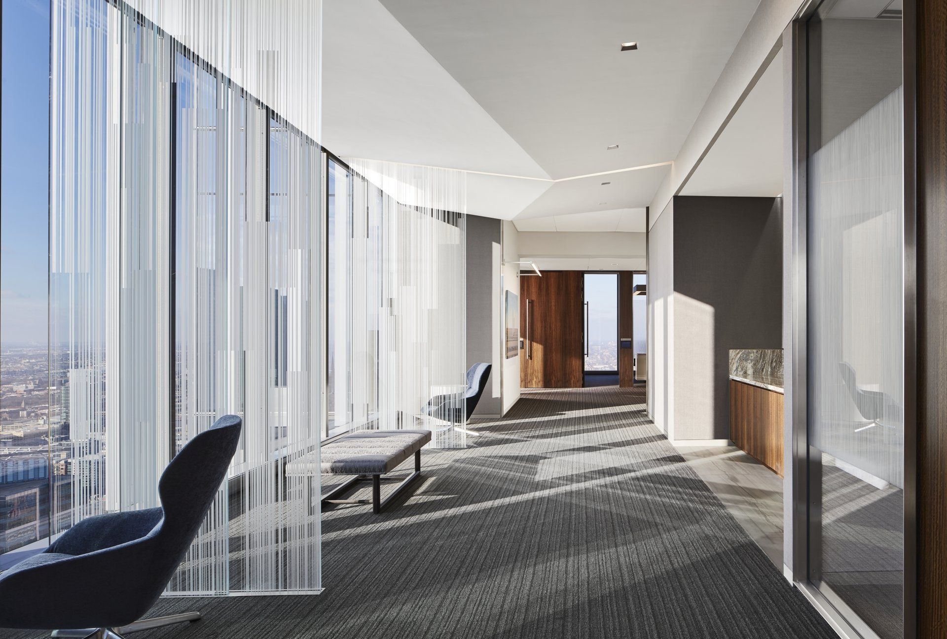 A long hallway with a lot of windows and chairs