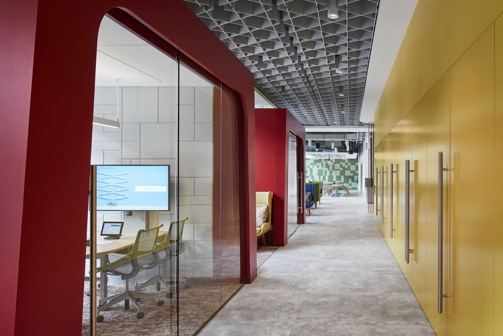 A long hallway with a glass door leading to a conference room.