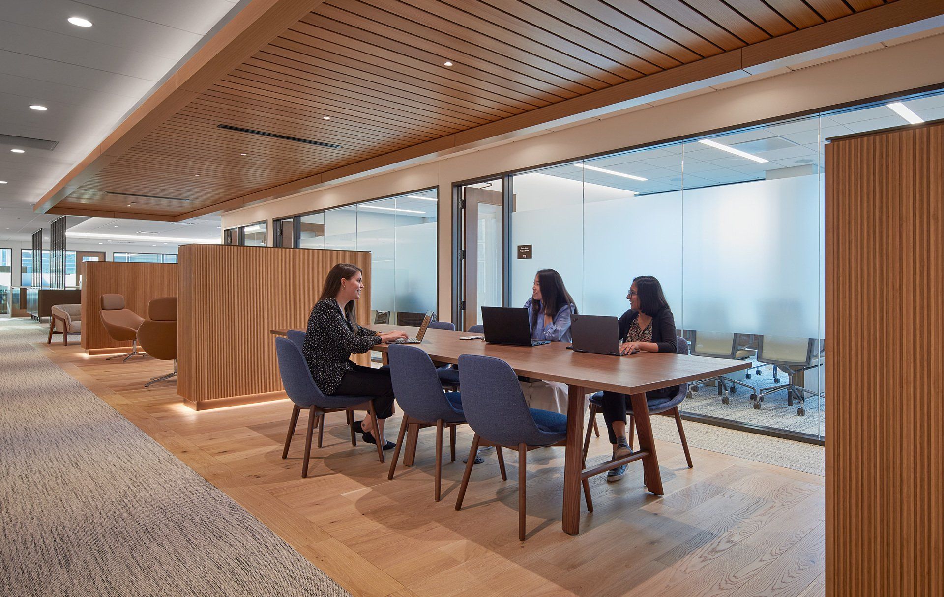 A group of women are sitting at a table in a conference room.