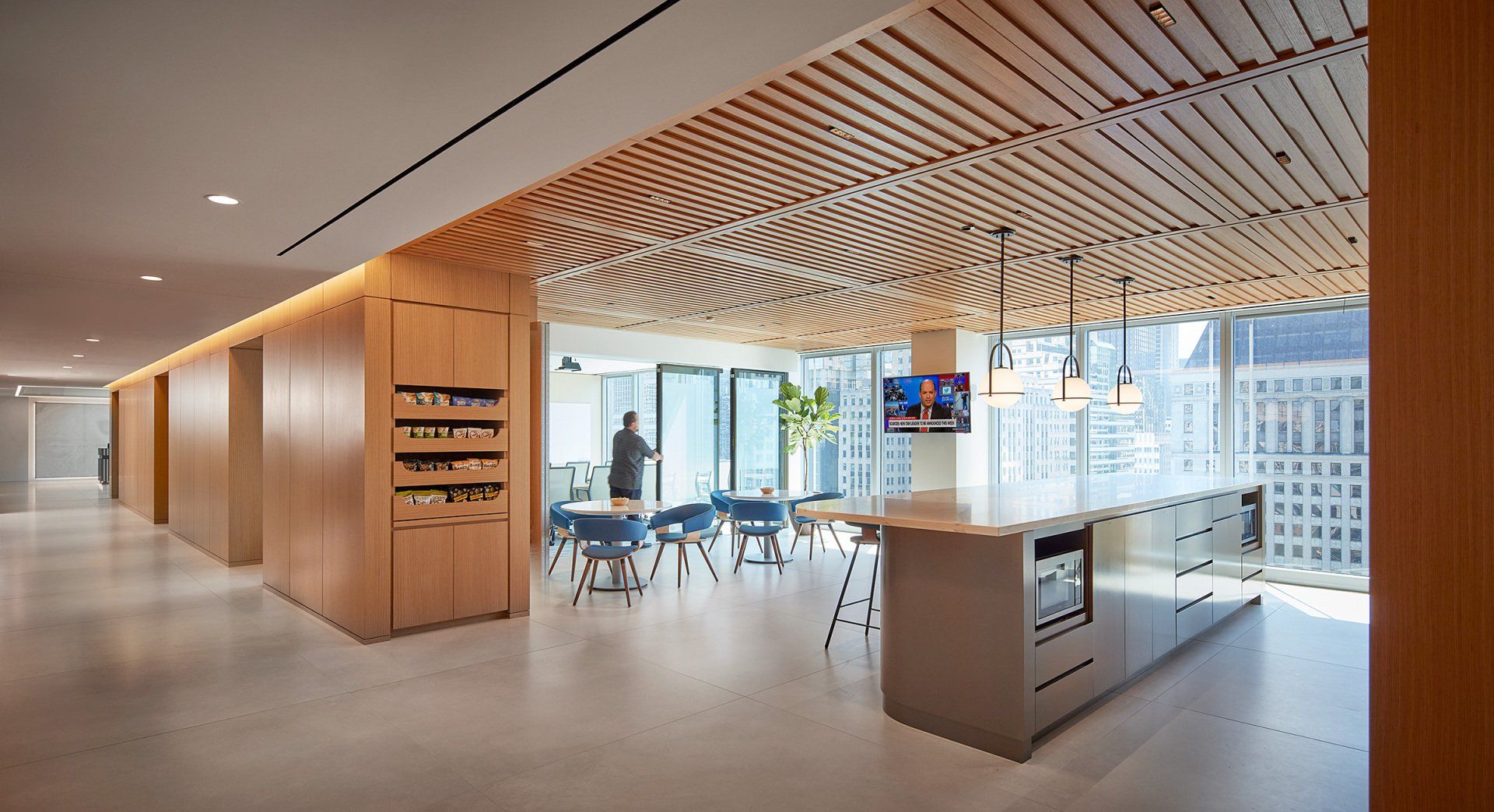 A large room with a wooden ceiling and tables and chairs.