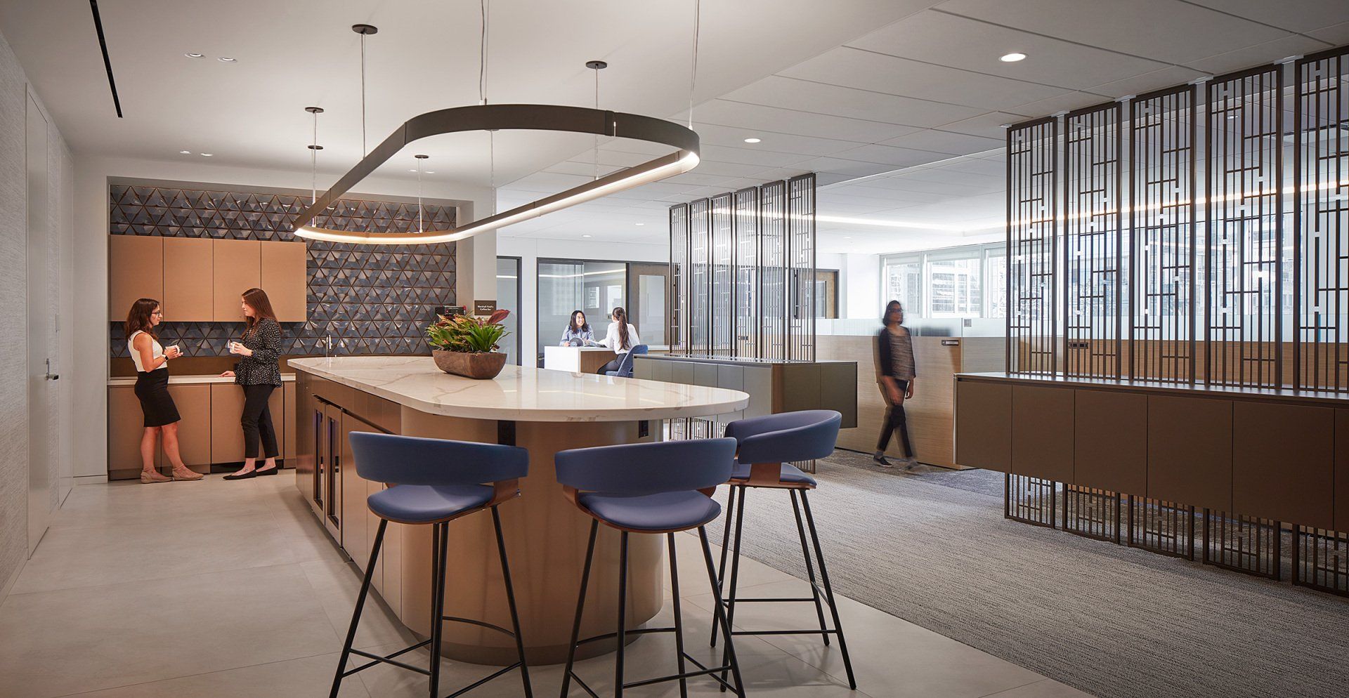 A group of people are standing around a table in a kitchen.