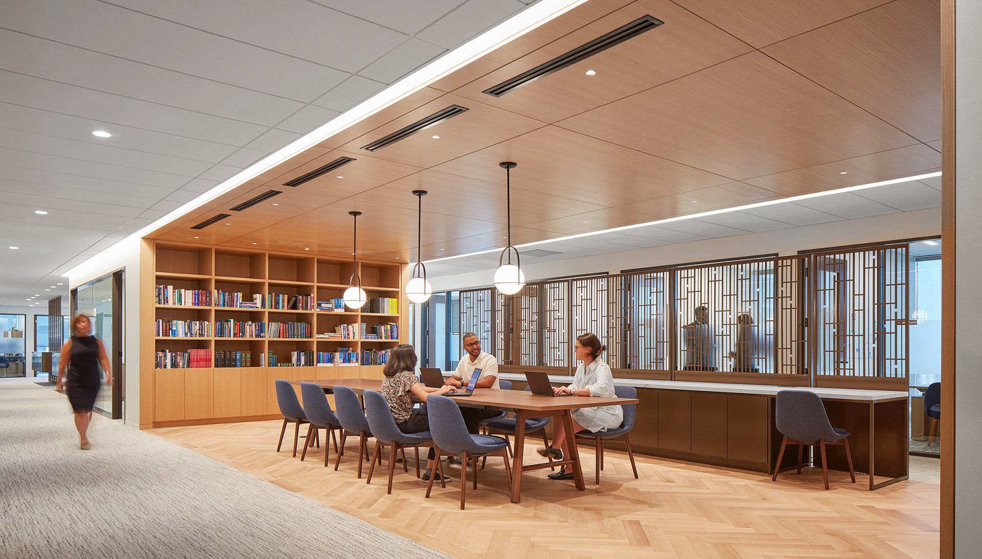 A group of people are sitting around a table in a library.