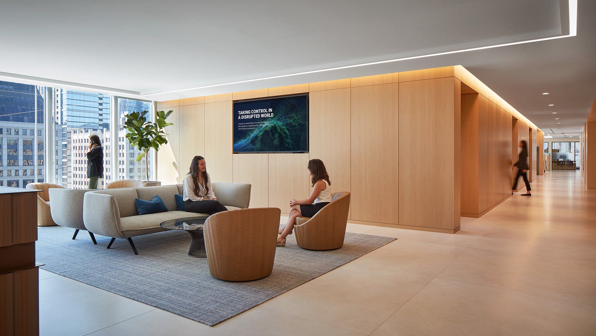 Two women are sitting on a couch in a living room.