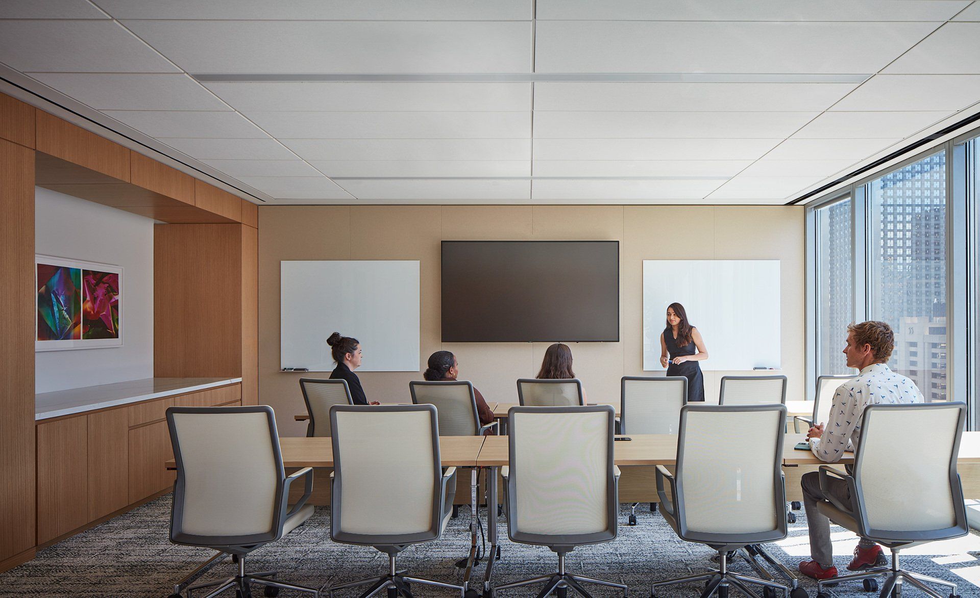 A group of people are sitting at tables in a conference room.