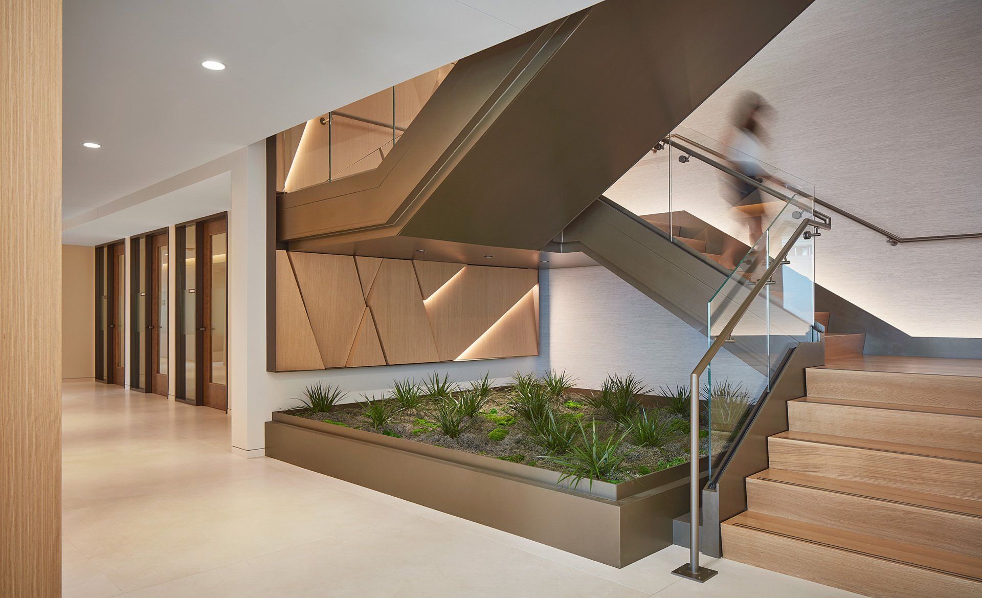 A woman is walking down a set of stairs in a building.