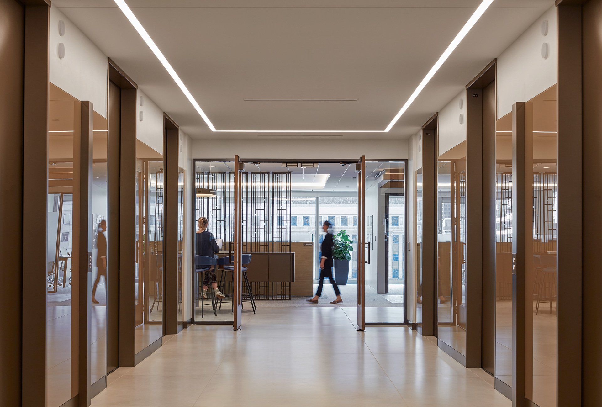 A man is walking down a hallway in an office building.