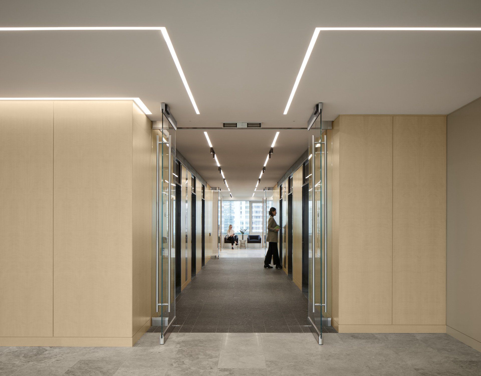 A man is walking down a hallway in an office building.