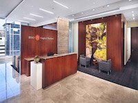 A large lobby with a wooden reception desk and chairs.