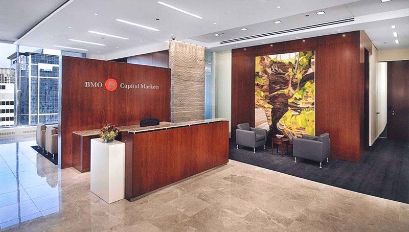 A large lobby with a wooden reception desk and chairs