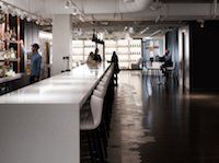 A blurred image of a restaurant with a long table and chairs.