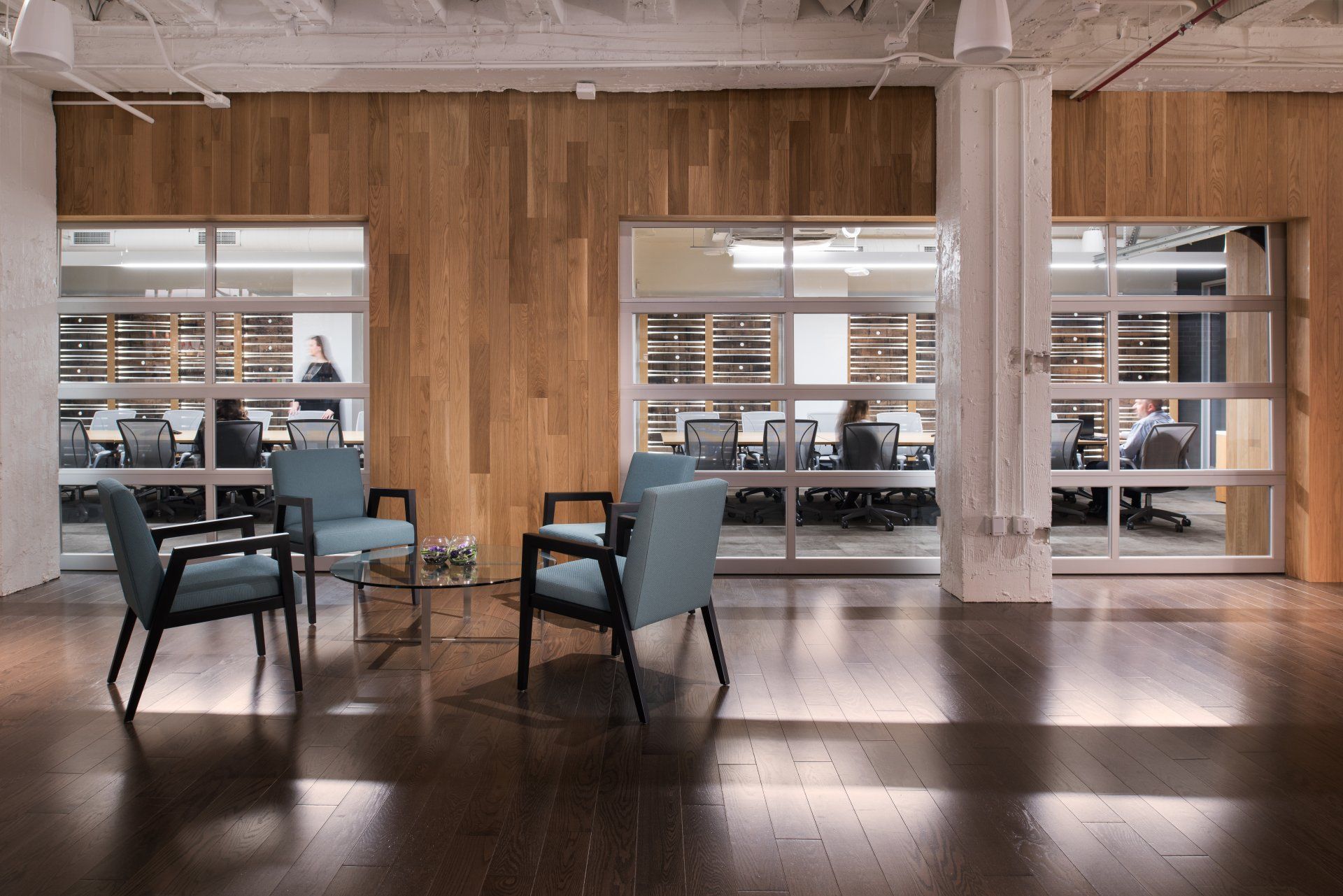 A room with chairs and a table in it and a wooden wall.