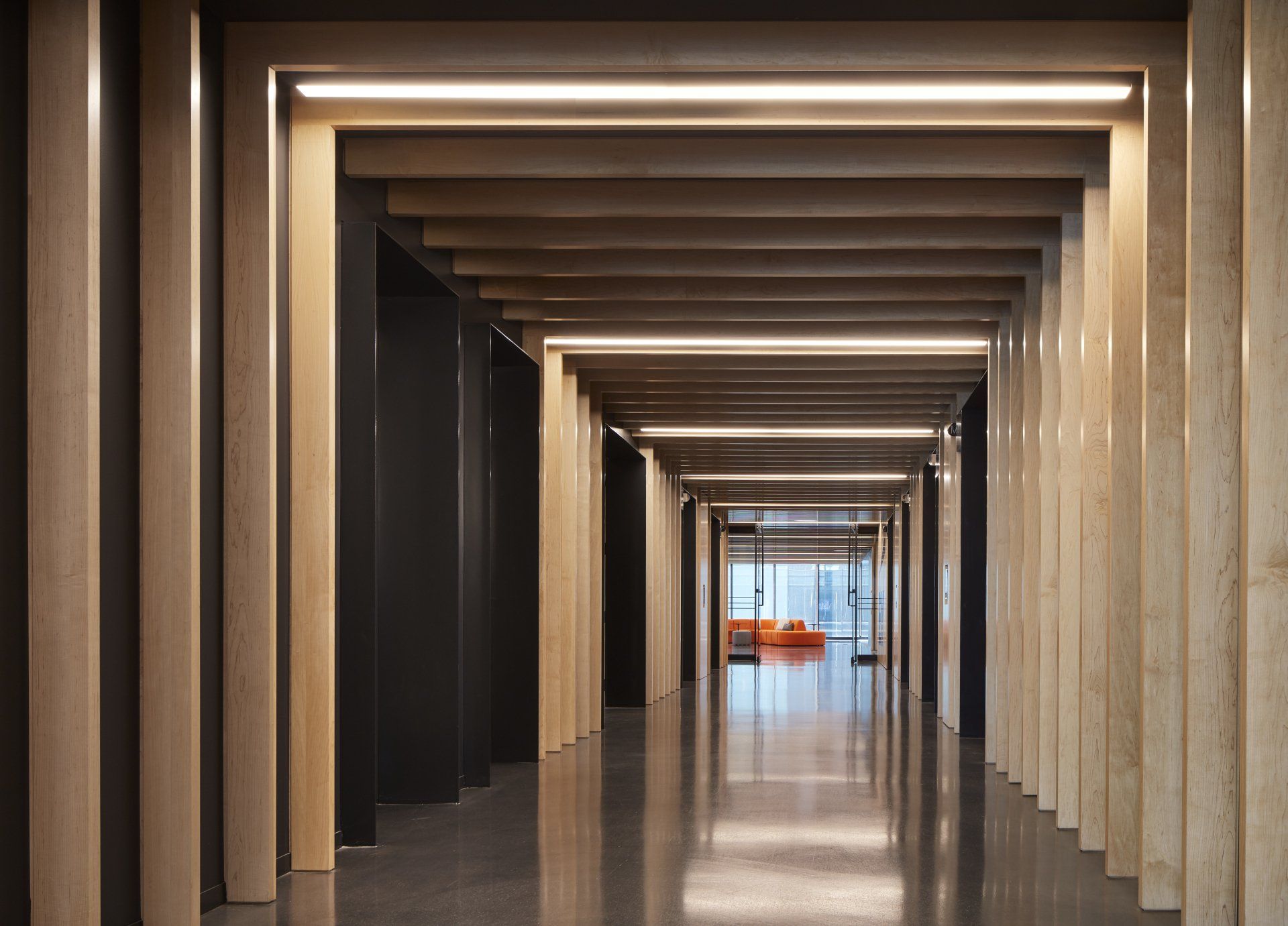 A long hallway with wooden walls and a concrete floor