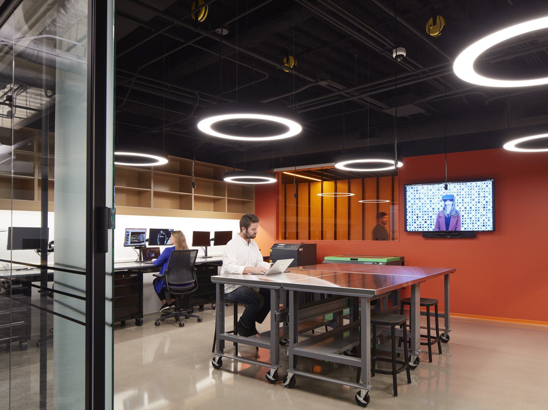 A man and a woman are sitting at a table in an office.