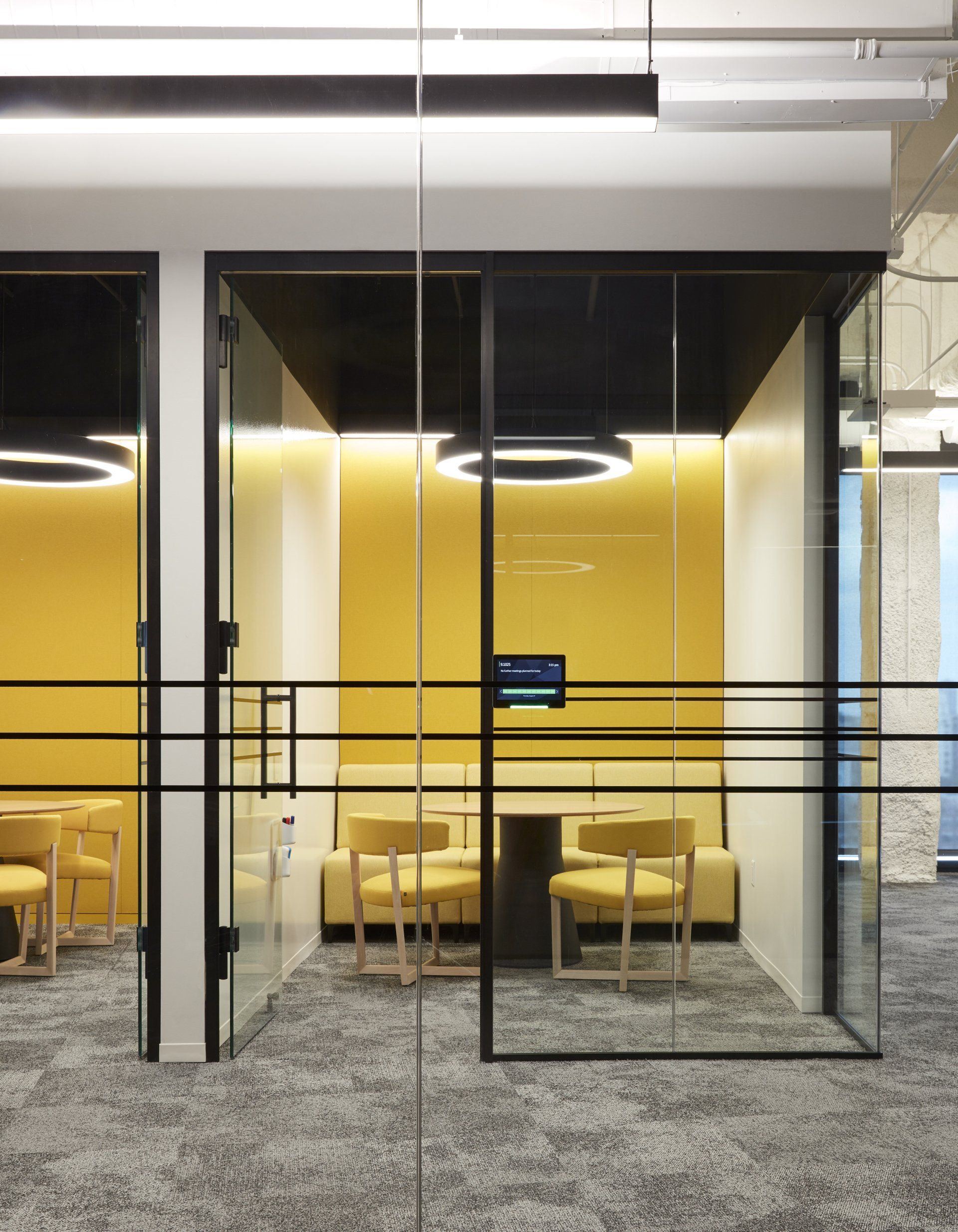 A room with a table and chairs behind glass doors