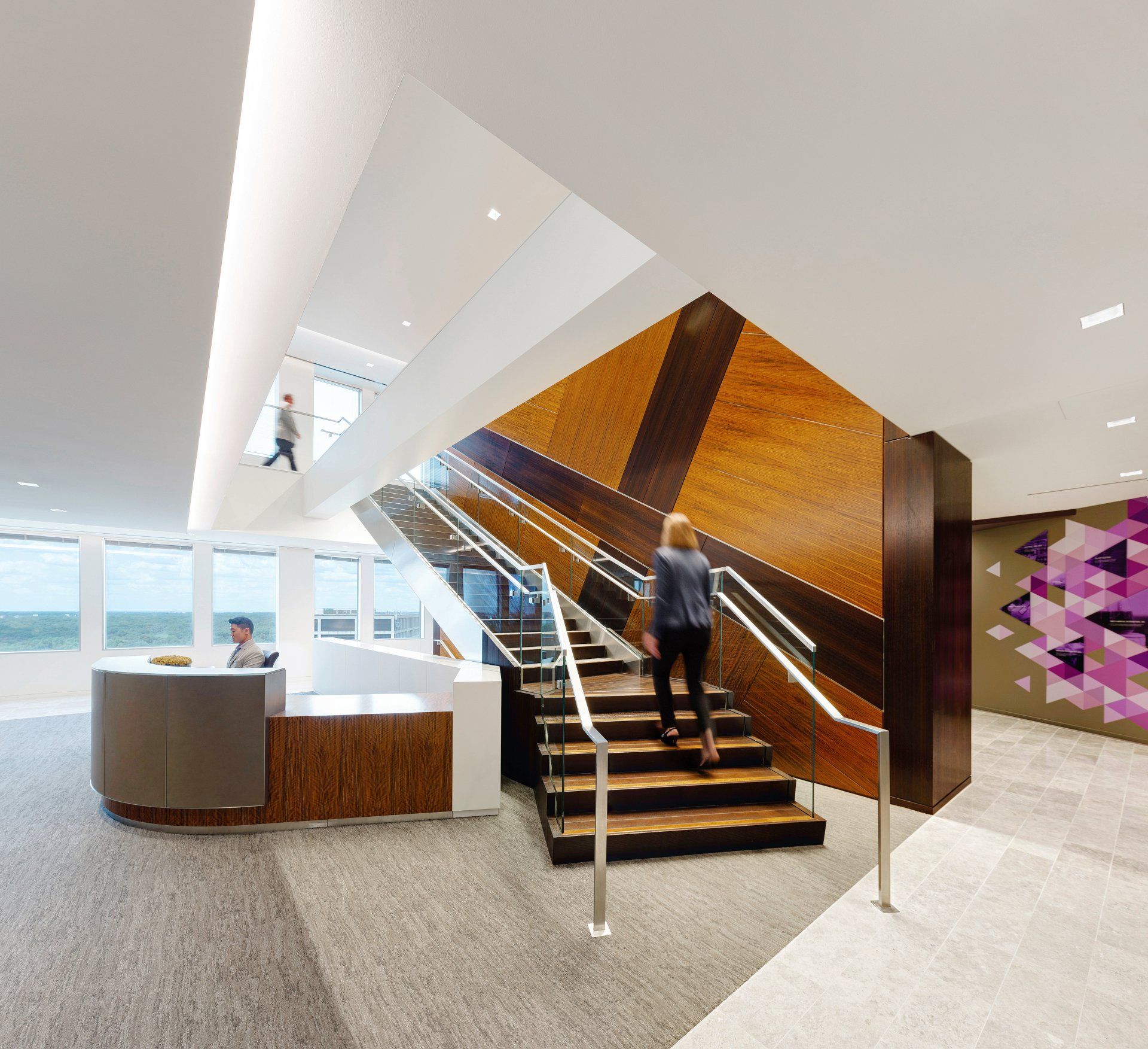 A woman is walking up a set of stairs in a lobby