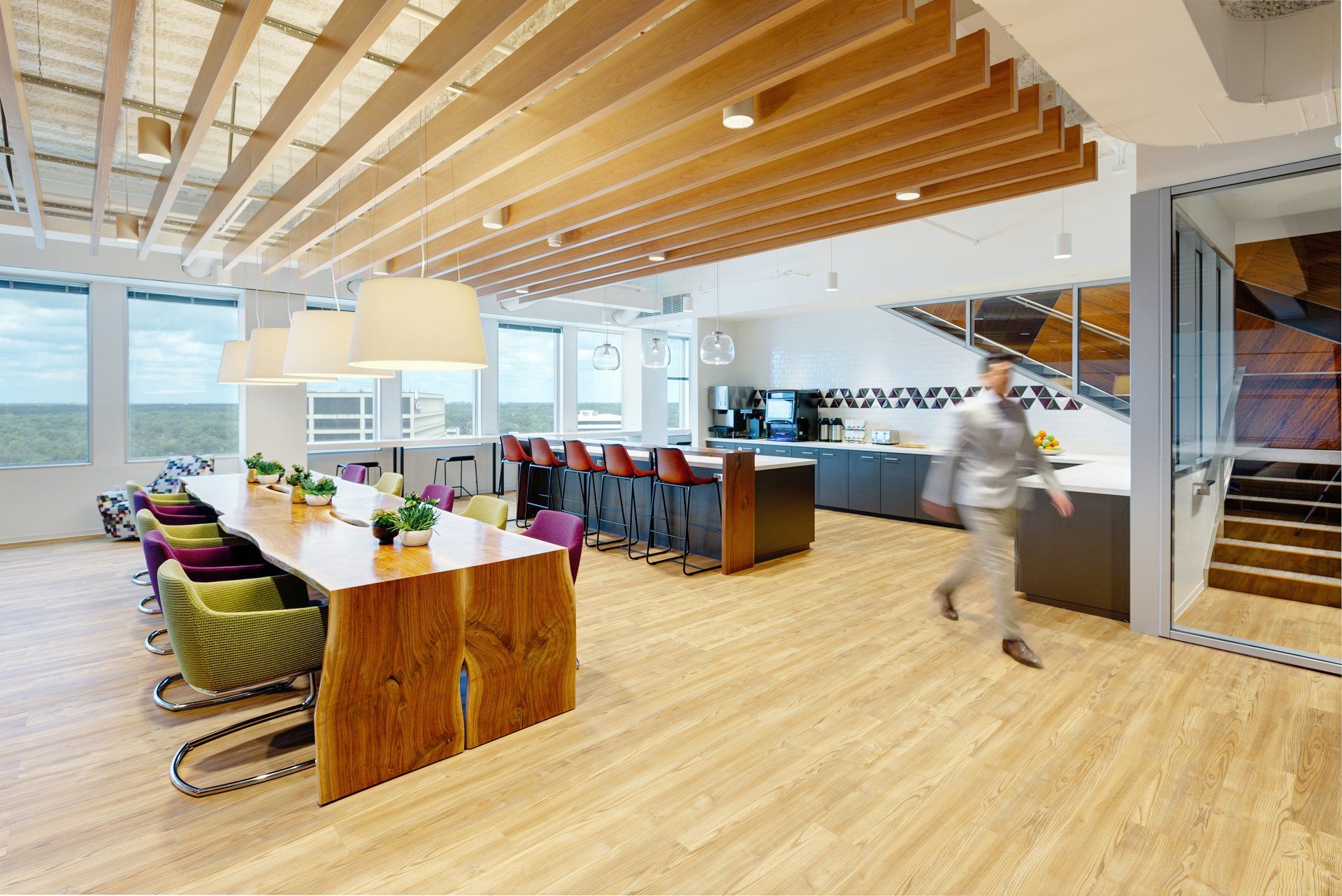 A man is walking through a large room with tables and chairs.