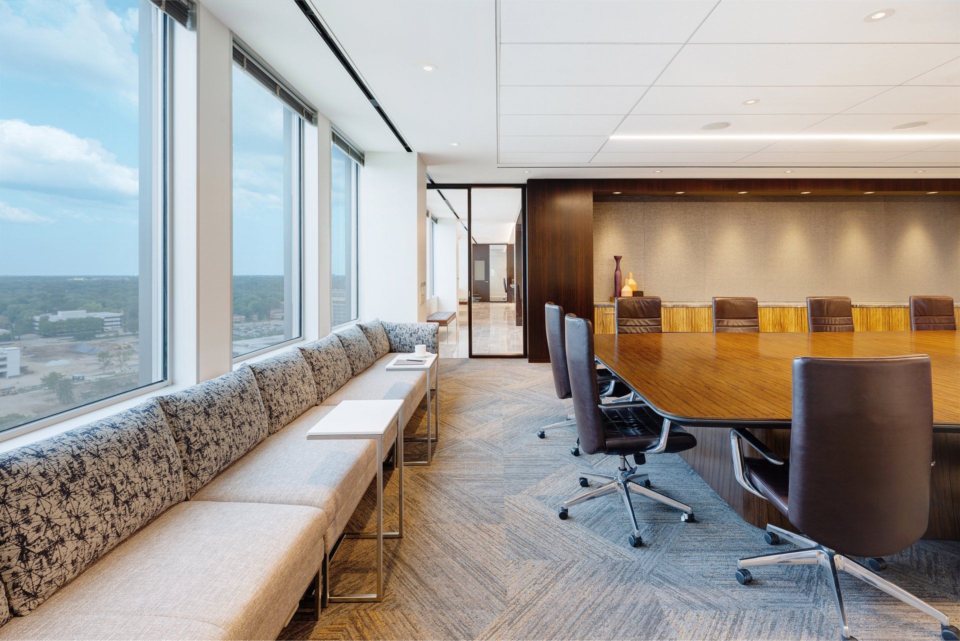 A conference room with a long table and chairs and a couch.