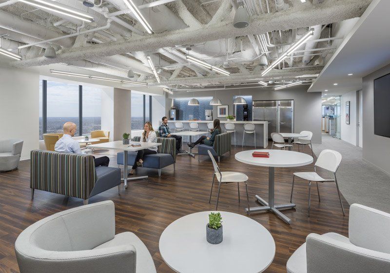 A group of people are sitting at tables in a large room.