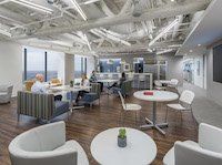 A group of people are sitting at tables in a large room.
