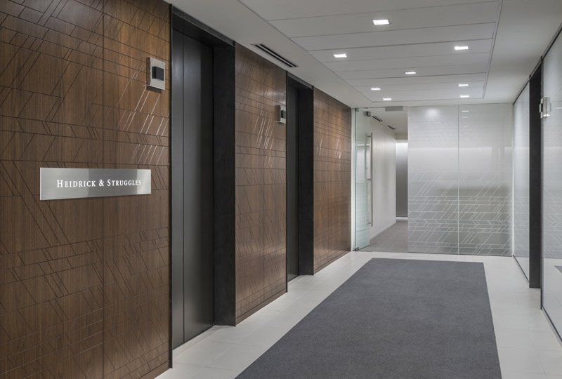 A long hallway with elevators in a building.