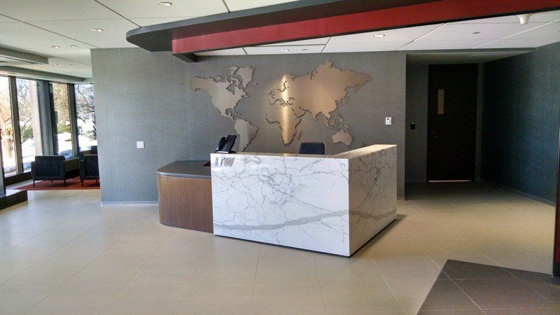 A lobby with a marble counter and a map of the world on the wall.