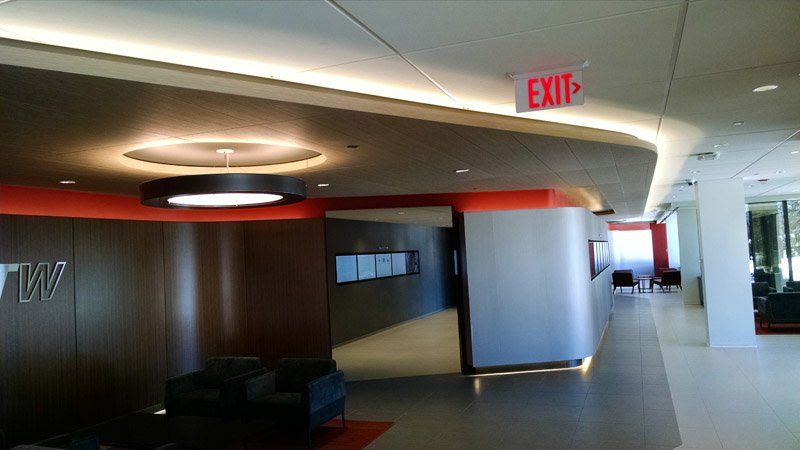 A large hallway with a red exit sign on the ceiling