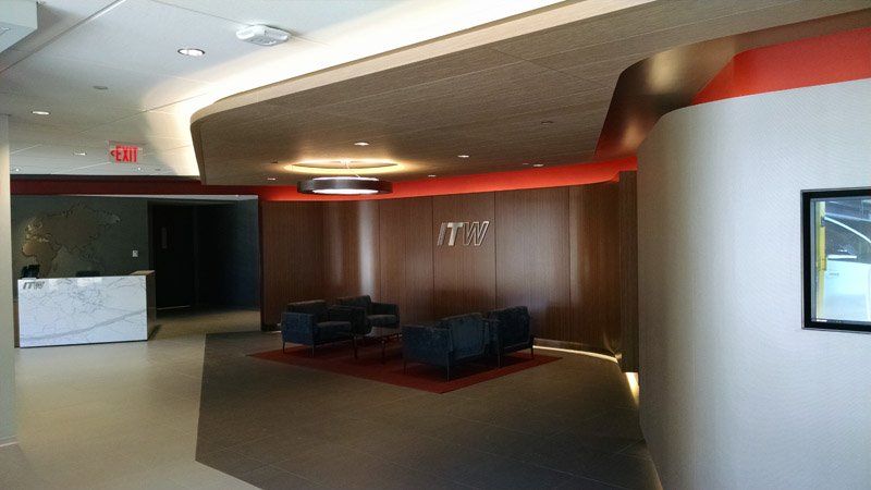 A large lobby with a red exit sign on the wall