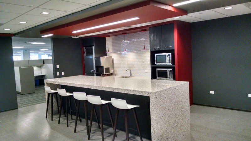 A kitchen with a long counter and stools