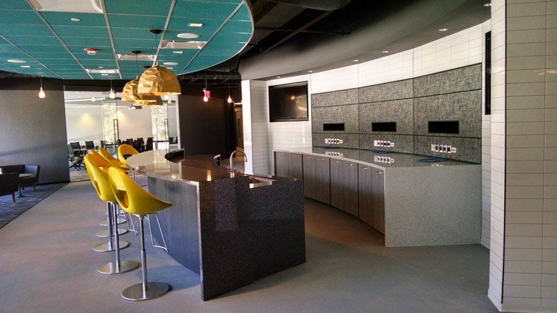 A kitchen with a large island and yellow chairs.