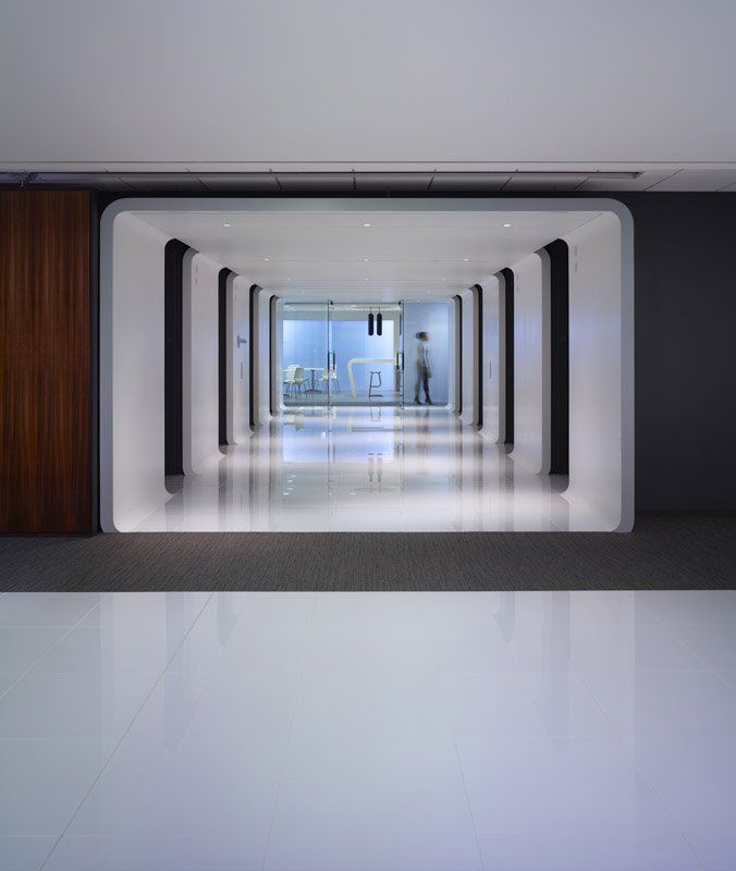 A long hallway with a few people walking through it