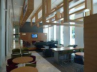 A long hallway with tables and chairs in a building.