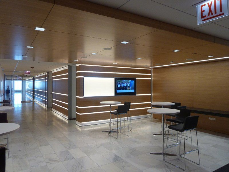 A hallway with tables and chairs and an exit sign