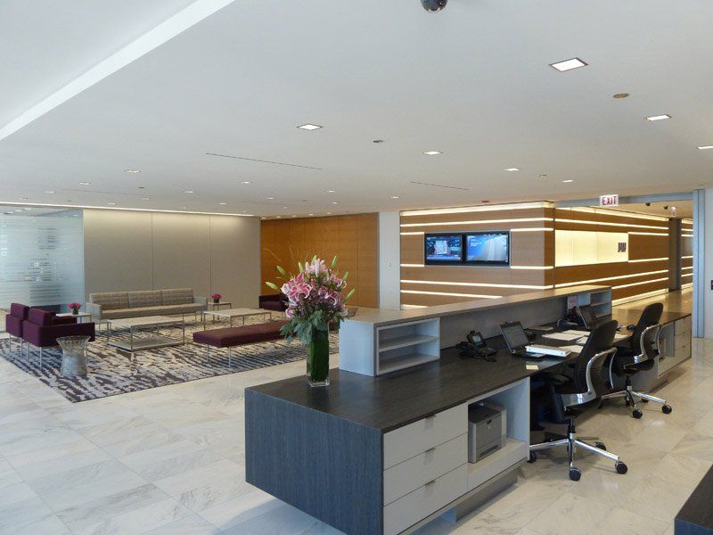 A large room with a table and chairs and a vase of flowers