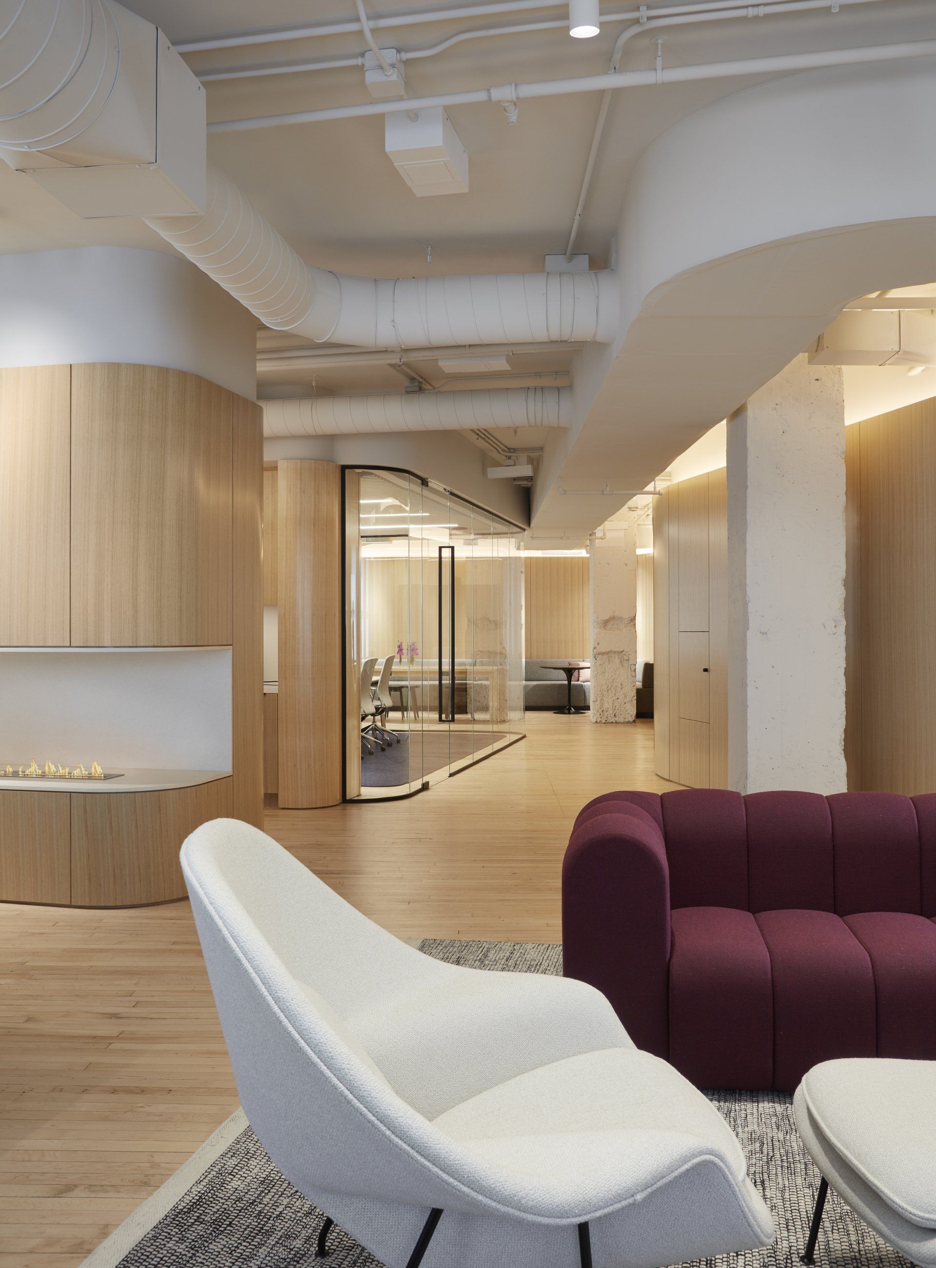 A living room with a purple couch and white chairs