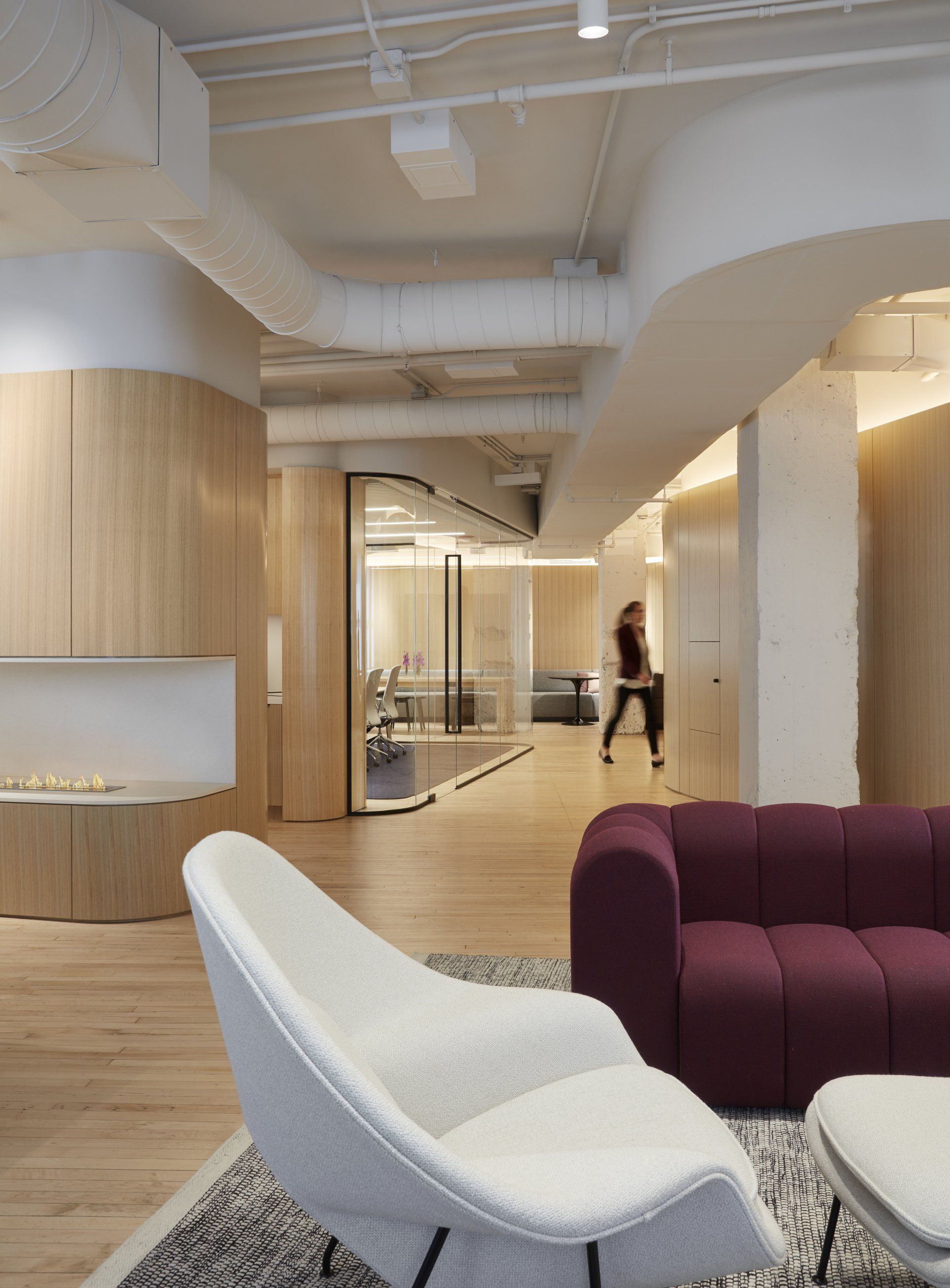 A living room with a purple couch and white chairs