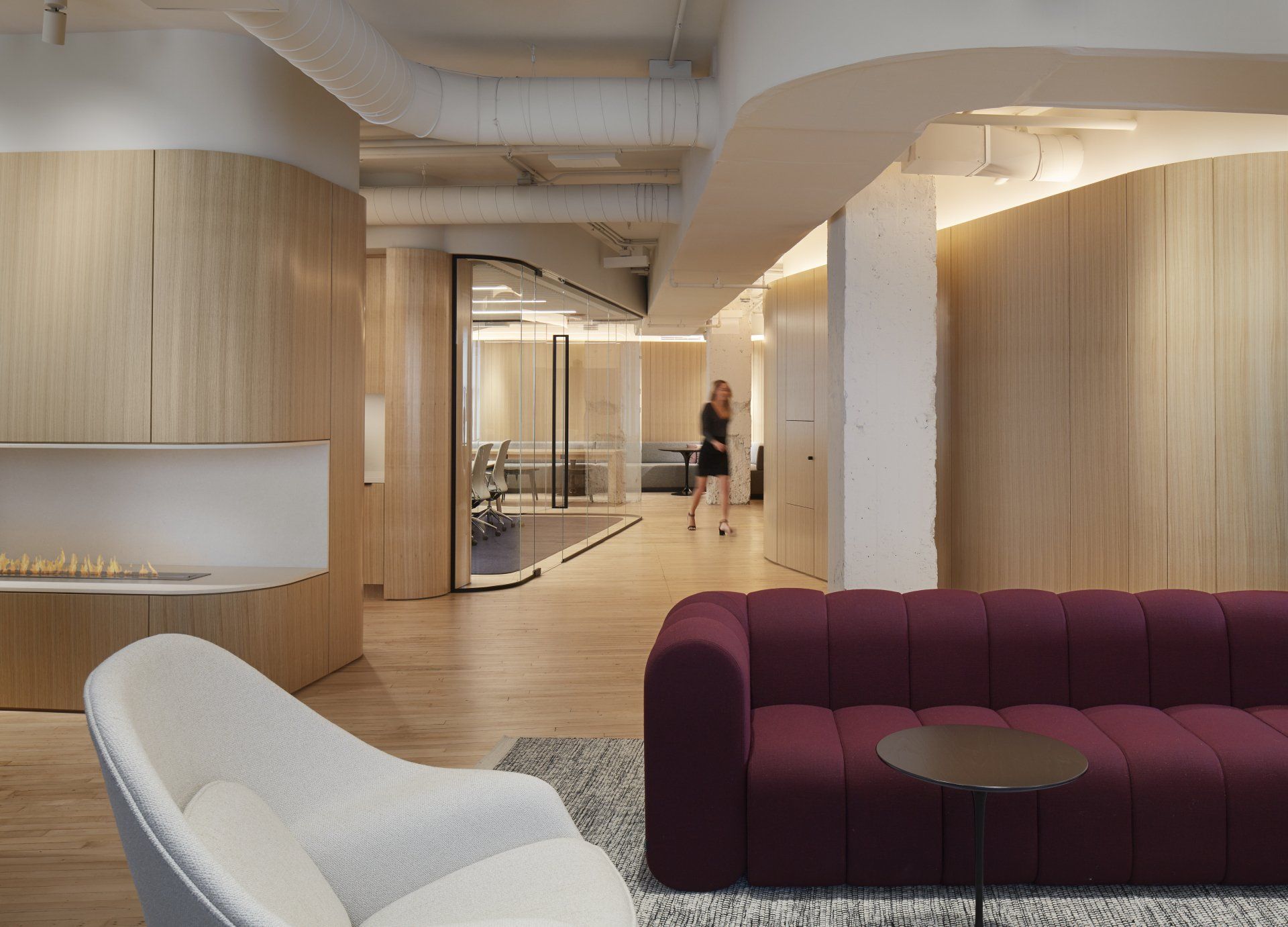 A living room with a purple couch and a white chair.