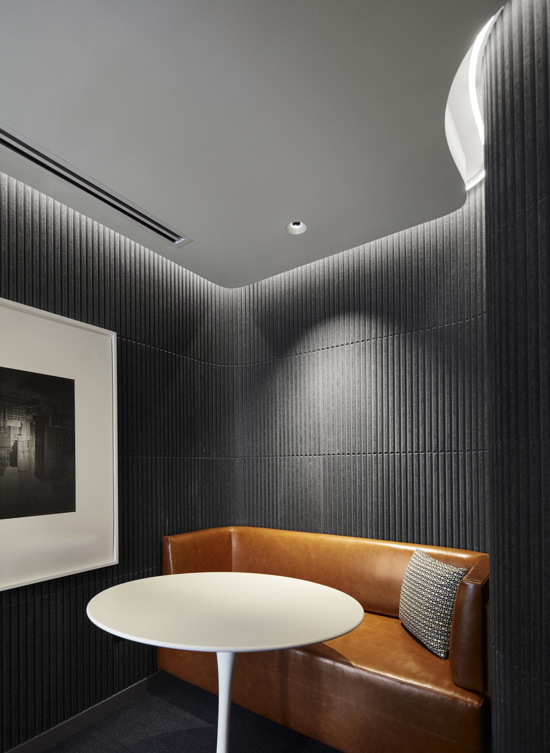 A room with a brown couch and a white table