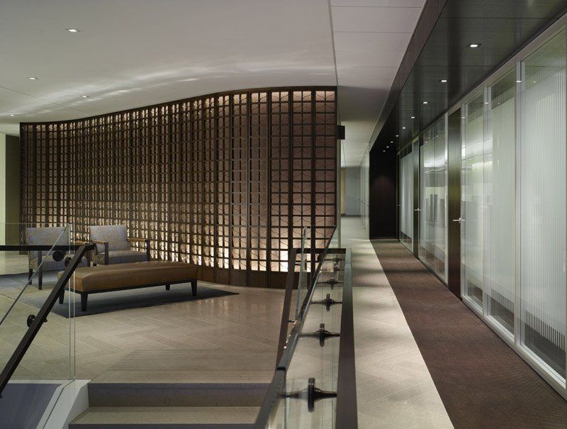A long hallway with a glass railing and a bench