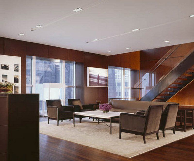 A living room with a couch and chairs and a staircase