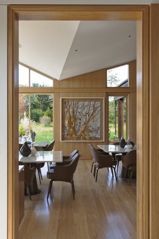 A dining room with tables and chairs and a painting on the wall