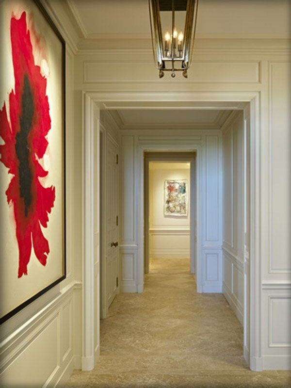 A hallway with a painting of a red flower on the wall