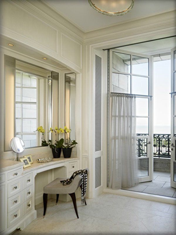 A vanity with a chair and a mirror in a room