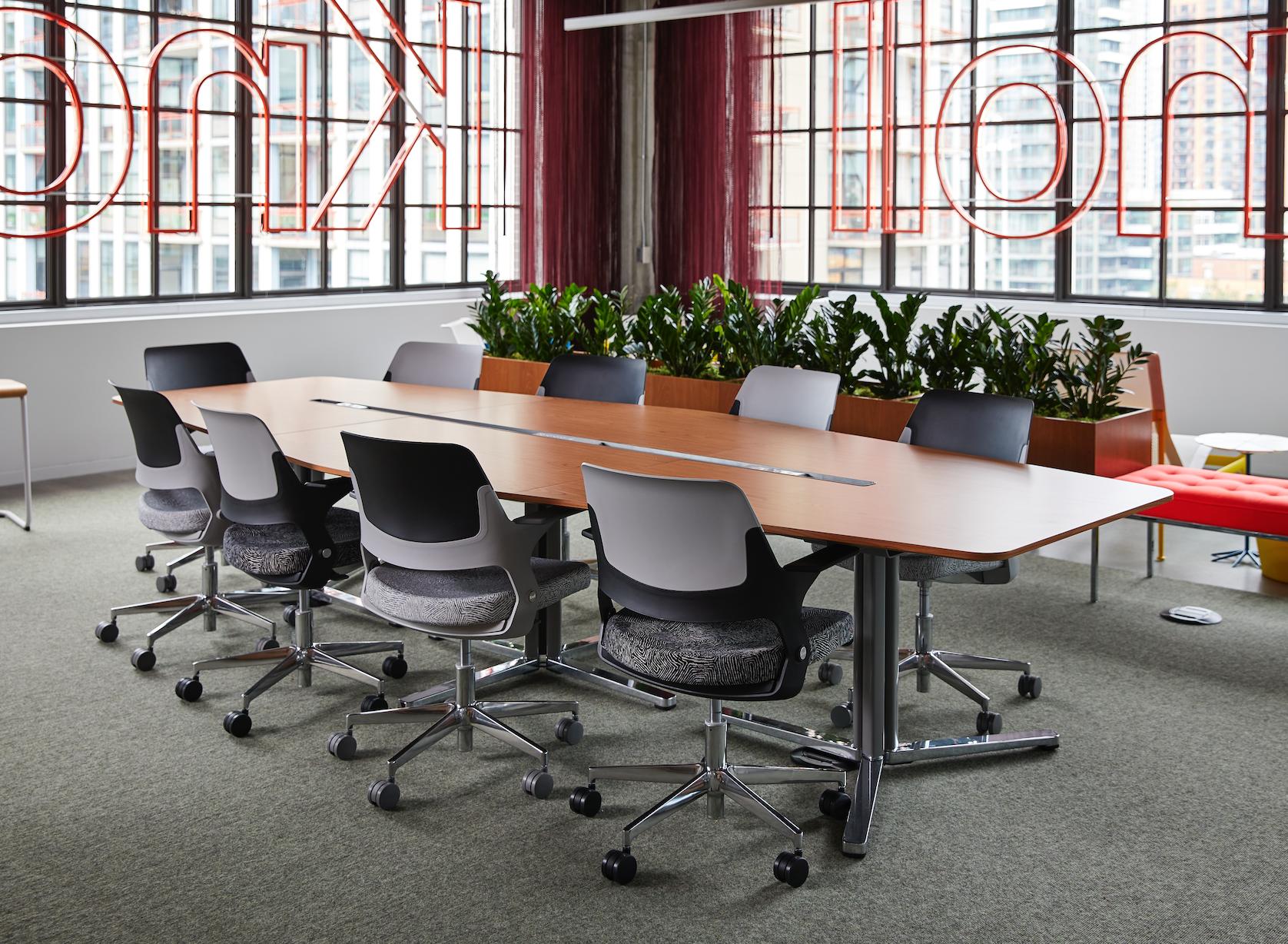 A conference room with a long wooden table and chairs.