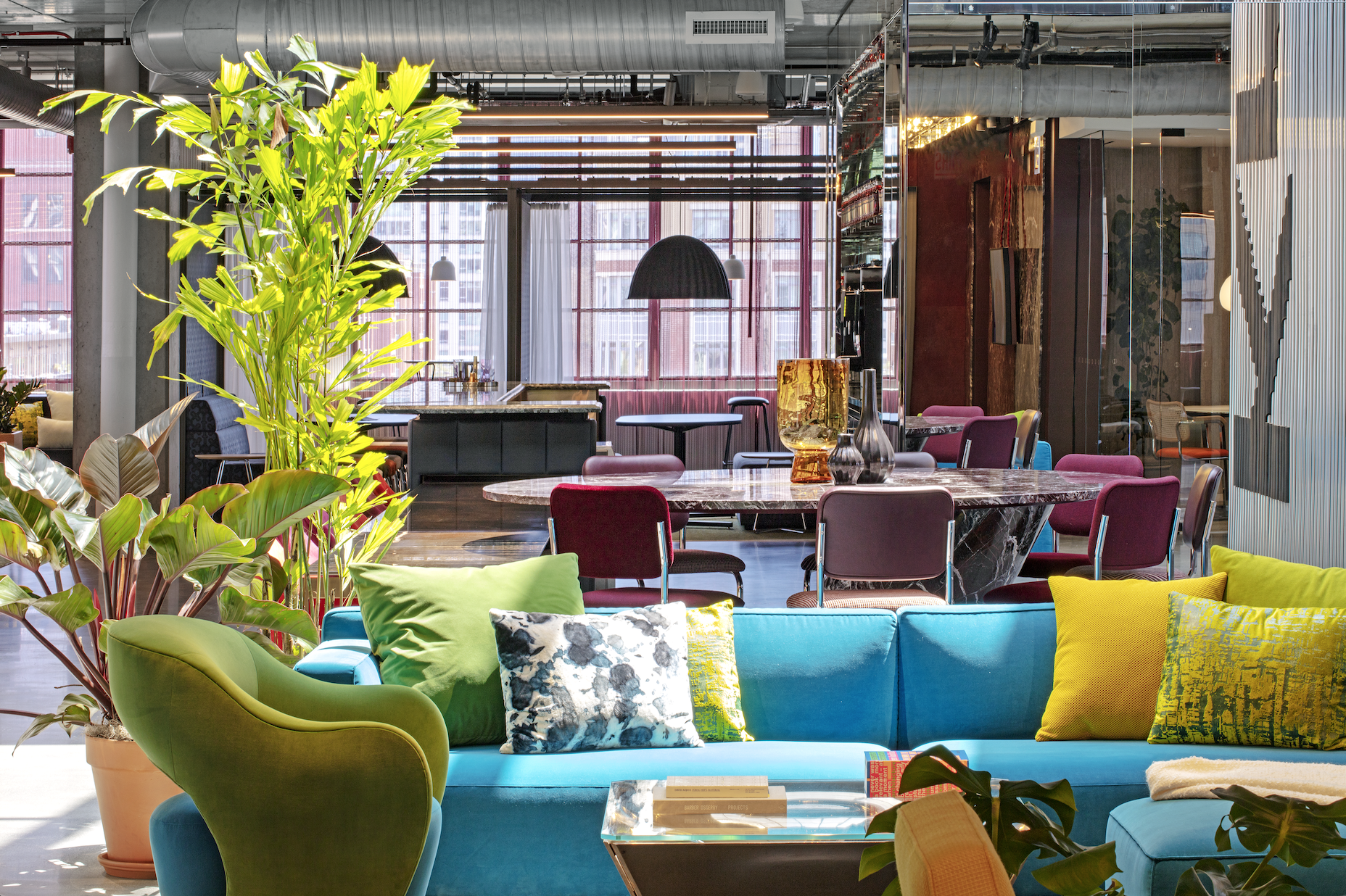 A living room with a blue couch and green chairs