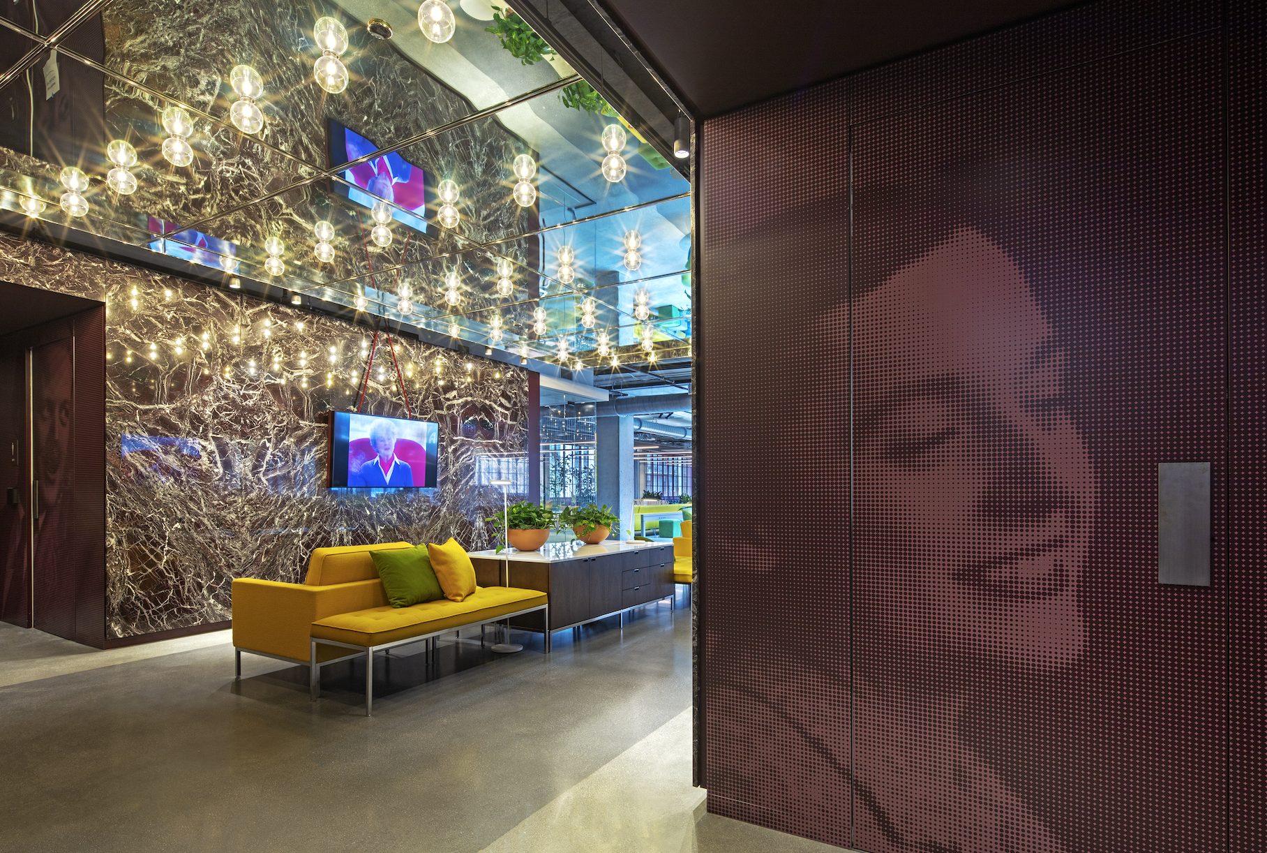 A living room with a yellow couch and a purple wall