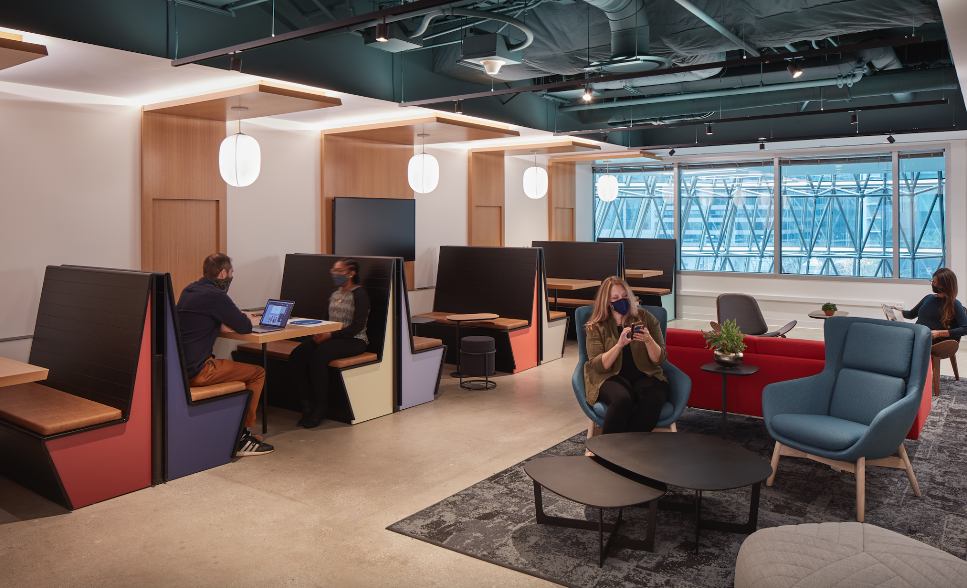 A group of people are sitting in booths in a room.