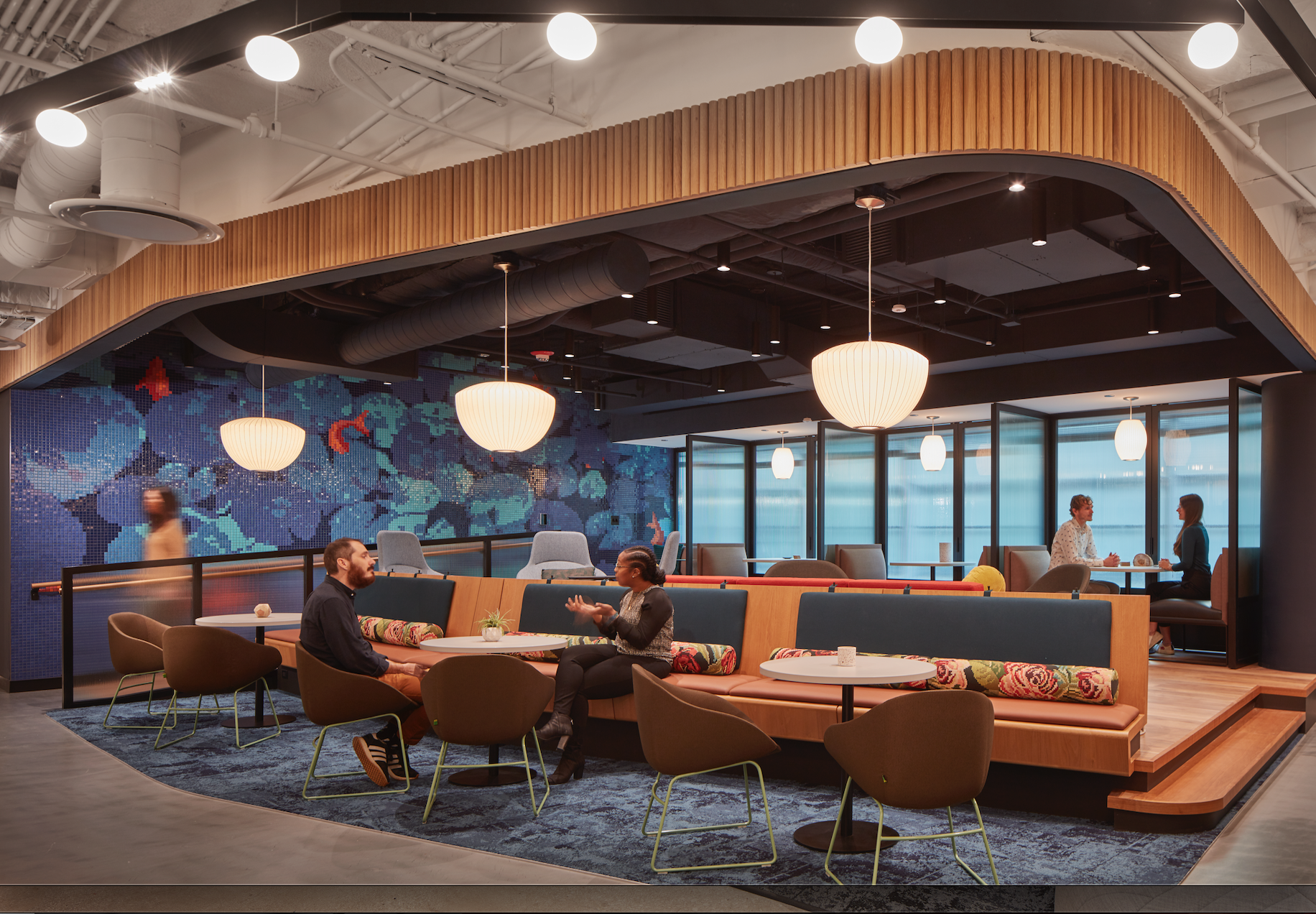 A group of people are sitting at tables in a restaurant.